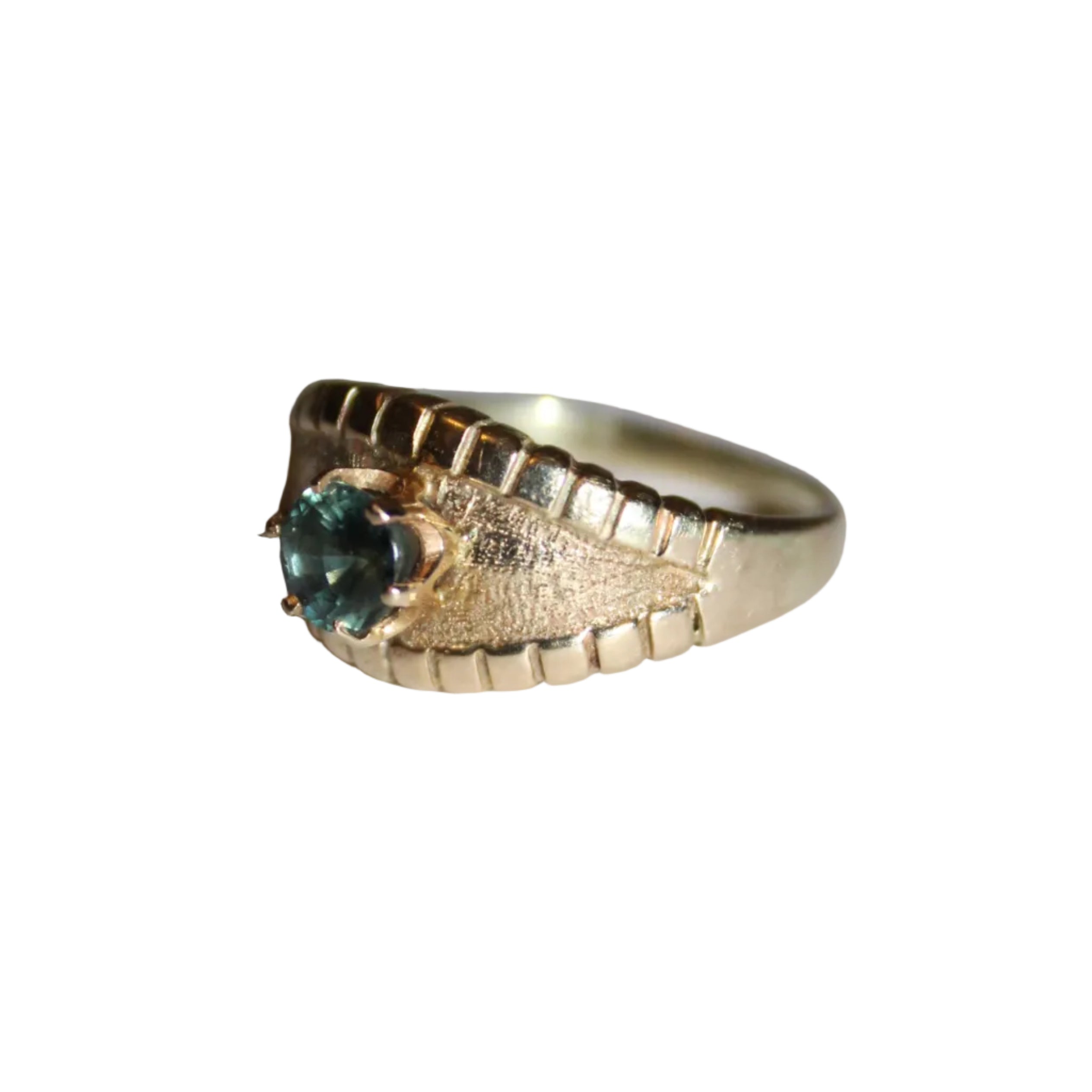 Gold ring with a green gemstone on a light gray background