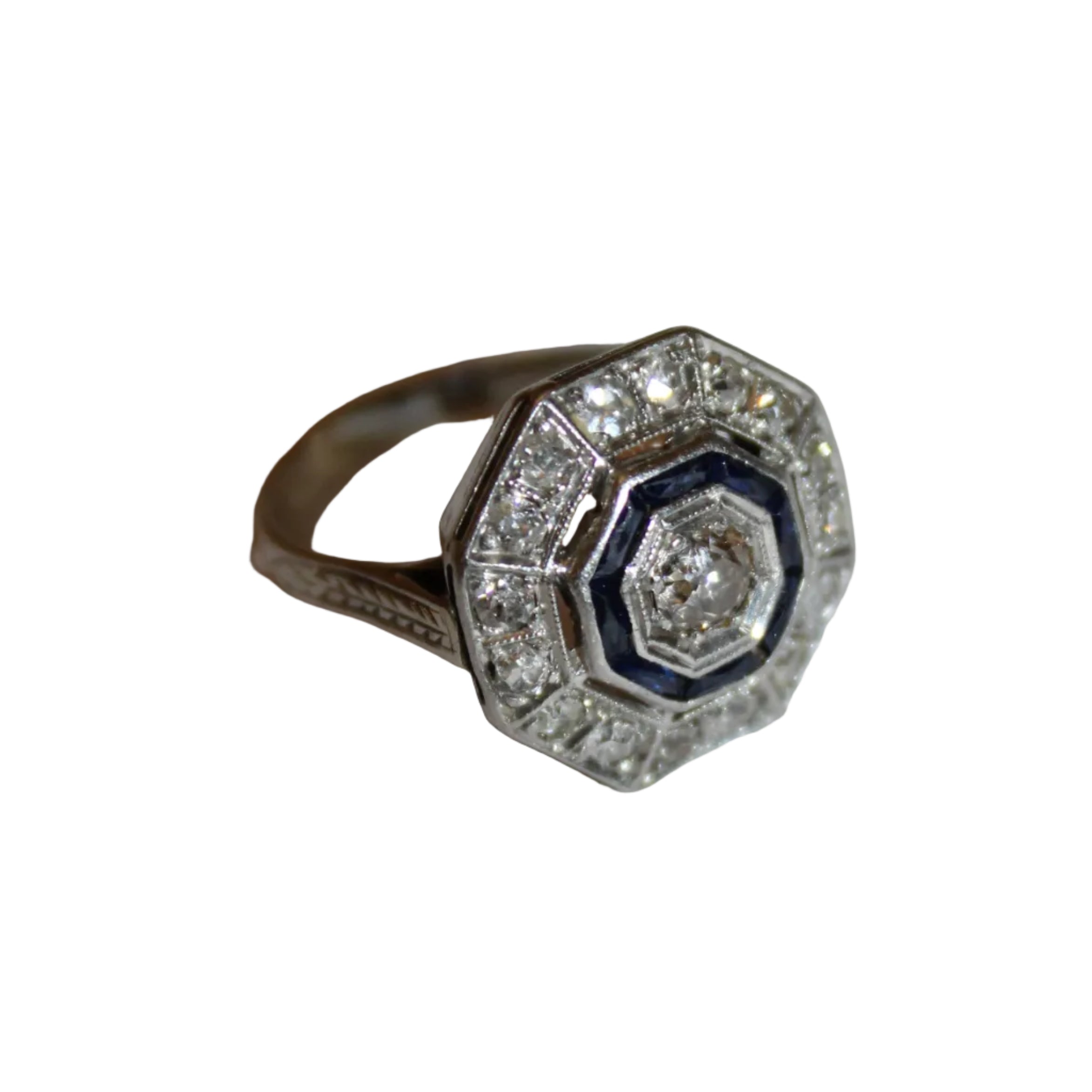 Silver ring with blue gemstone and clear stones on a light gray background