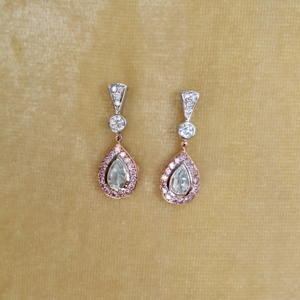 Teardrop-shaped earrings with gemstones on a beige fabric background
