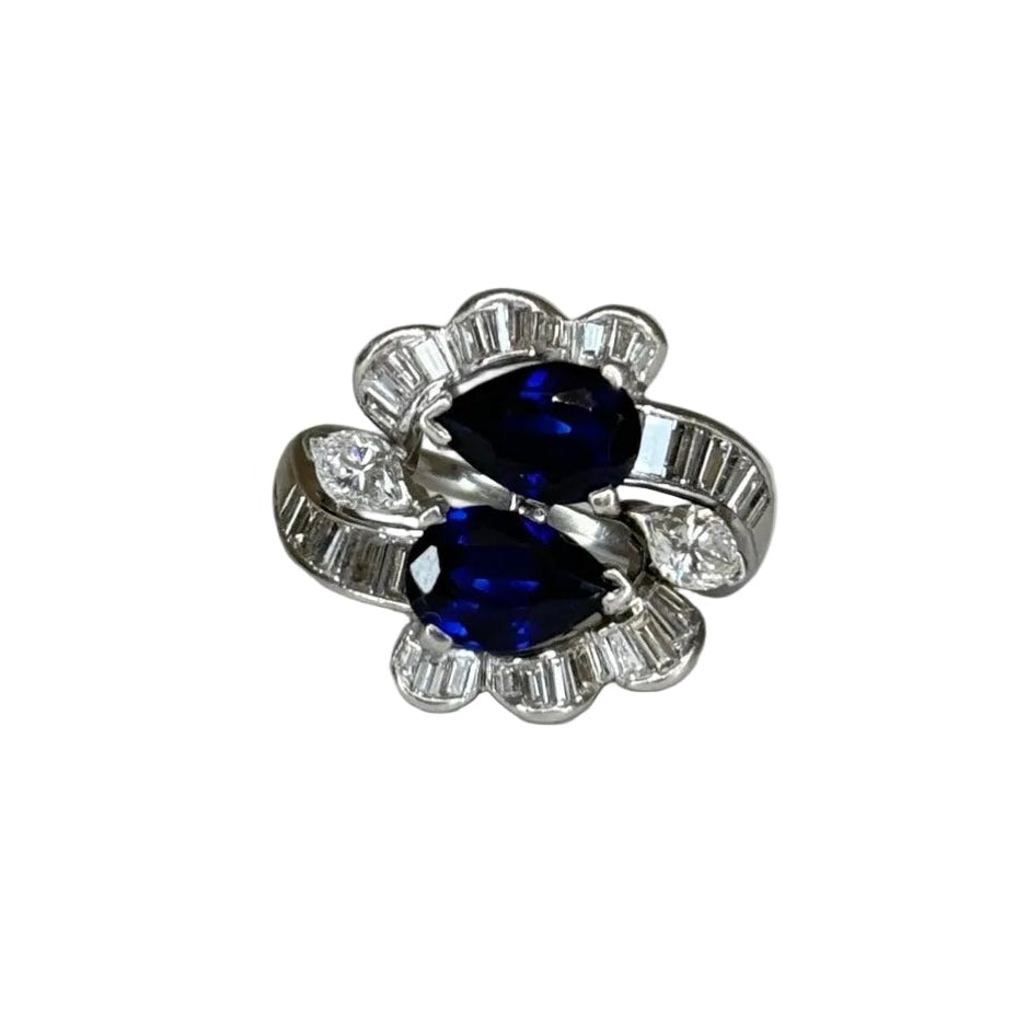 Silver ring with blue gemstone and diamonds on a white background