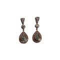 Pair of teardrop-shaped earrings with gemstones on a light gray background