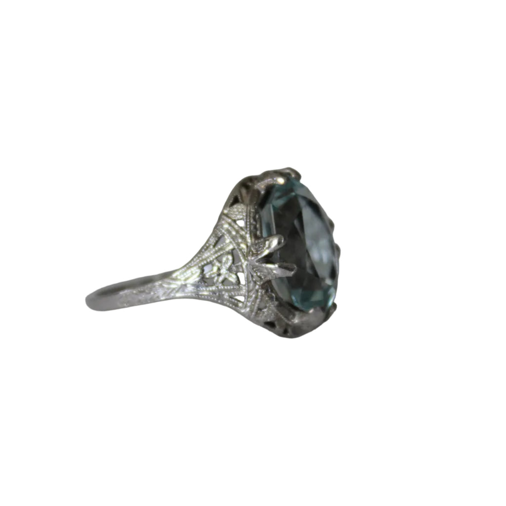 Silver ring with a large blue gemstone on a light gray background